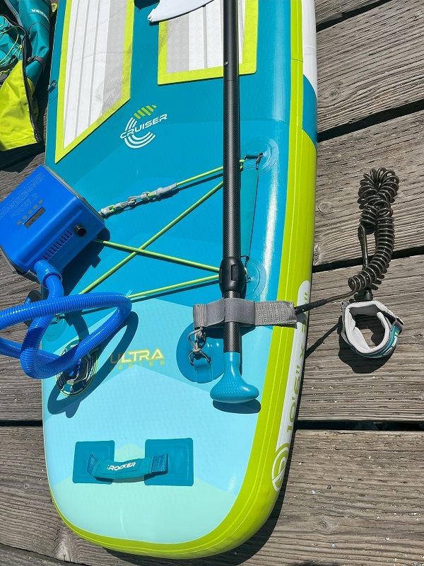 A paddle-holding leash is attached to a D-ring on the iRocker Cruiser Ultra 2.0 paddle board